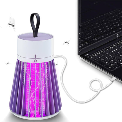 Purple insect repellent lamp next to a laptop on a white background